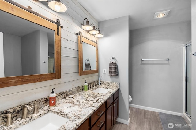 3007 Belmonte Ln, Everett, WA 98201 - bathroom featuring double vanity, toilet, a shower stall, wood finished floors, and baseboards