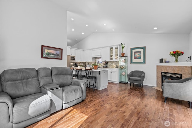 3016 97th Pl SE, Everett, WA 98208 - living area featuring recessed lighting, wood finished floors, a tiled fireplace, high vaulted ceiling, and baseboards
