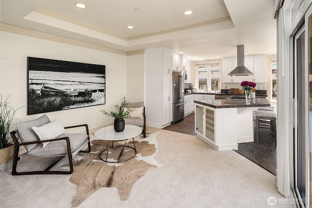 221 5th Ave S Unit E303, Kirkland, WA 98033 - kitchen featuring wall chimney exhaust hood, freestanding refrigerator, a tray ceiling, recessed lighting, and a breakfast bar area