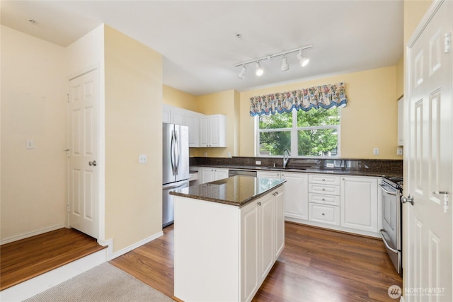 3116 164th St SW Unit 1704, Lynnwood, WA 98087 - kitchen with appliances with stainless steel finishes, white cabinets, dark wood-type flooring, a center island, and dark stone counters