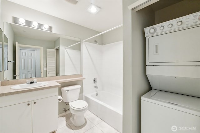 3116 164th St SW Unit 1704, Lynnwood, WA 98087 - full bathroom featuring stacked washing machine and dryer, toilet, vanity, tile patterned flooring, and  shower combination