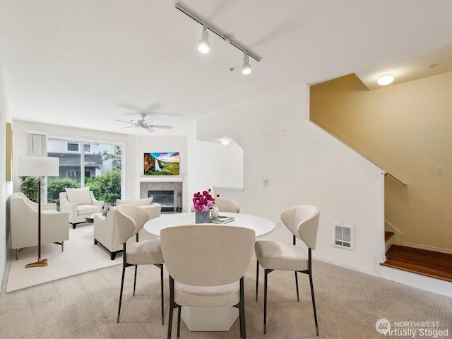 3116 164th St SW Unit 1704, Lynnwood, WA 98087 - dining room with light carpet, ceiling fan, stairway, a glass covered fireplace, and rail lighting