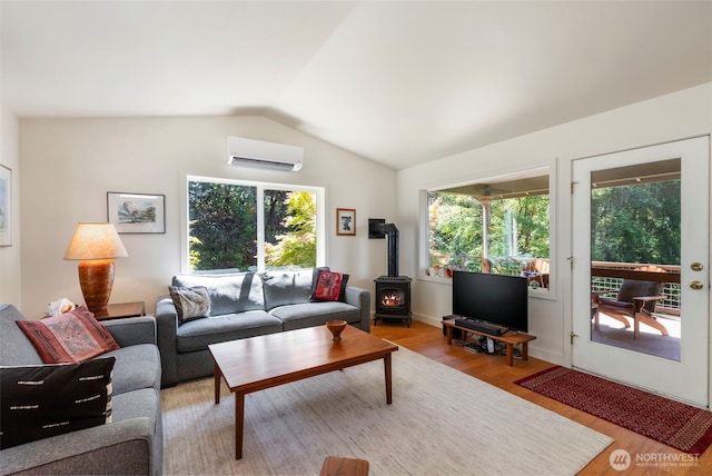 512 Snagstead Way, Port Townsend, WA 98368 - living area with a wall mounted AC, a wood stove, light wood finished floors, and lofted ceiling