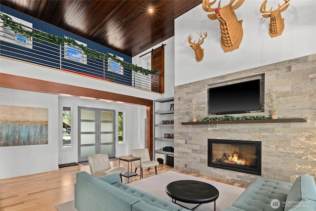 501 Maple Leaf Loop, Cle Elum, WA 98922 - living room with wooden ceiling, a fireplace, wood finished floors, a towering ceiling, and built in shelves
