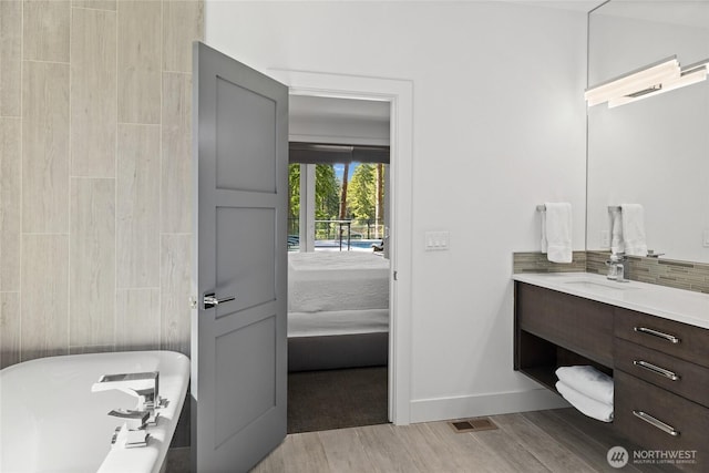 501 Maple Leaf Loop, Cle Elum, WA 98922 - full bathroom with vanity, wood finished floors, a soaking tub, baseboards, and ensuite bathroom