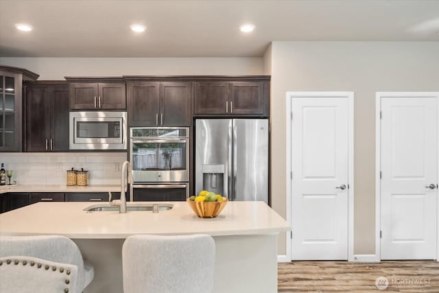 12304 55th Dr SE, Snohomish, WA 98296 - kitchen with stainless steel appliances, a sink, light wood-style flooring, dark brown cabinets, and recessed lighting