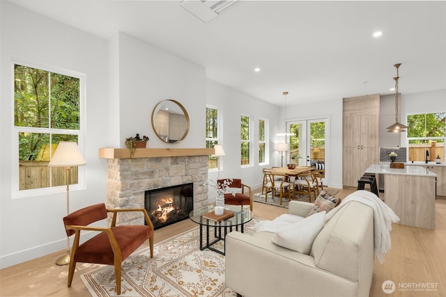 12837 NE 91st St, Kirkland, WA 98033 - living room featuring healthy amount of natural light, light wood-type flooring, recessed lighting, and a stone fireplace