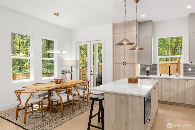 12837 NE 91st St, Kirkland, WA 98033 - kitchen with modern cabinets, light countertops, decorative backsplash, light wood-style flooring, and recessed lighting
