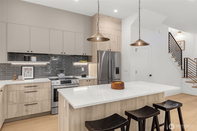 12837 NE 91st St, Kirkland, WA 98033 - kitchen featuring stainless steel appliances, light brown cabinets, a breakfast bar, light wood-style floors, and recessed lighting