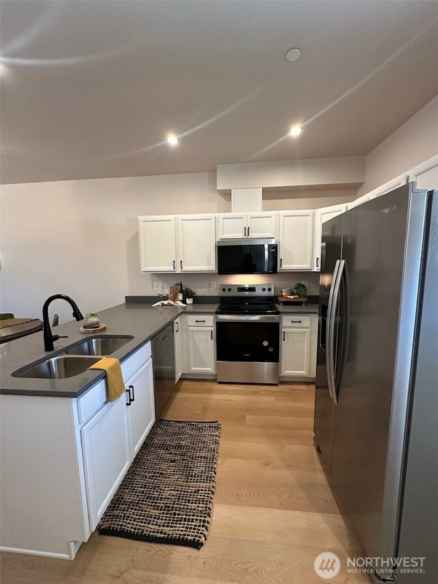 1712 Sunup Loop, Bellingham, WA 98226 - kitchen featuring stainless steel appliances, light wood-type flooring, dark countertops, white cabinetry, and recessed lighting