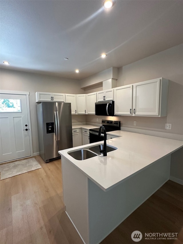 1714 Sunup Loop, Bellingham, WA 98226 - kitchen with stainless steel appliances, a peninsula, light wood-style flooring, light countertops, and white cabinets