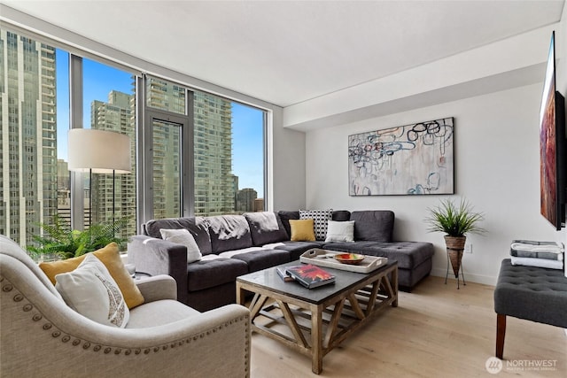 2510 6th Ave Unit 2003, Seattle, WA 98121 - living room featuring plenty of natural light, light wood finished floors, a city view, and a wall of windows