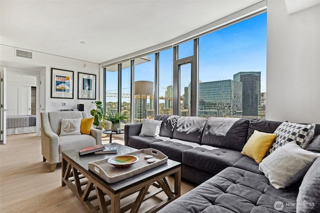 2510 6th Ave Unit 2003, Seattle, WA 98121 - living room featuring a wall of windows, a view of skyline, and light wood-style flooring