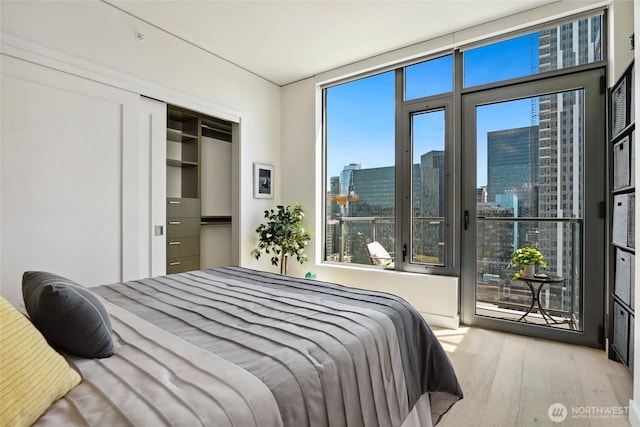 2510 6th Ave Unit 2003, Seattle, WA 98121 - bedroom featuring wood finished floors, access to exterior, and a view of city