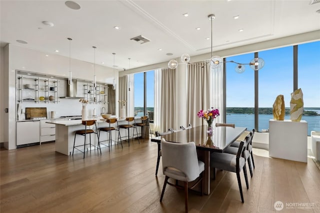 2510 6th Ave Unit 2003, Seattle, WA 98121 - dining space with dark wood-style floors, a water view, a wall of windows, and recessed lighting