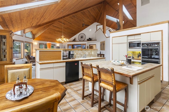 280 Surf St, Westport, WA 98595 - kitchen featuring black dishwasher, tile countertops, stainless steel microwave, light tile patterned floors, and a sink