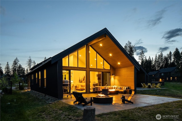 30 Symphony Ct, Cle Elum, WA 98922 - back of property at dusk with an outdoor living space with a fire pit, a patio area, and a lawn
