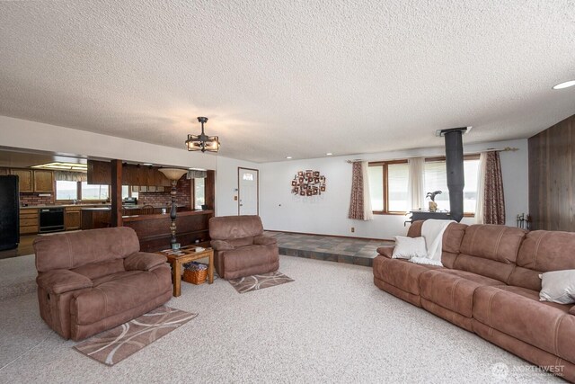710 S Mckinney Rd, Othello, WA 99344 - carpeted living area featuring a textured ceiling and a chandelier