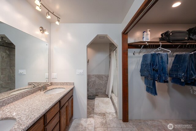 710 S Mckinney Rd, Othello, WA 99344 - bathroom with double vanity, a tile shower, and a spacious closet
