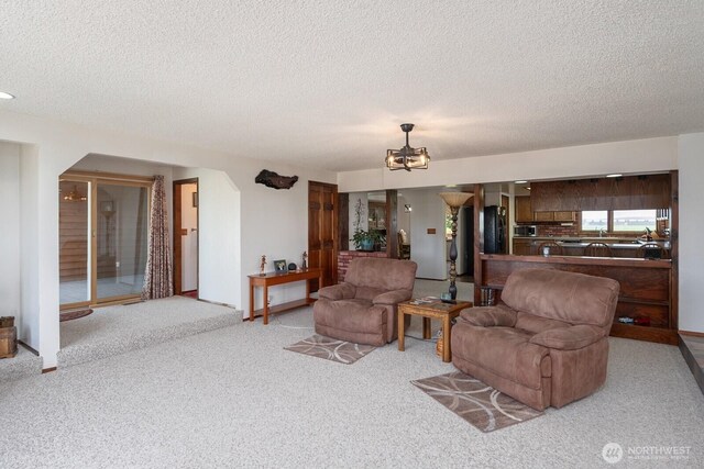 710 S Mckinney Rd, Othello, WA 99344 - living room featuring a textured ceiling, light colored carpet, and a chandelier