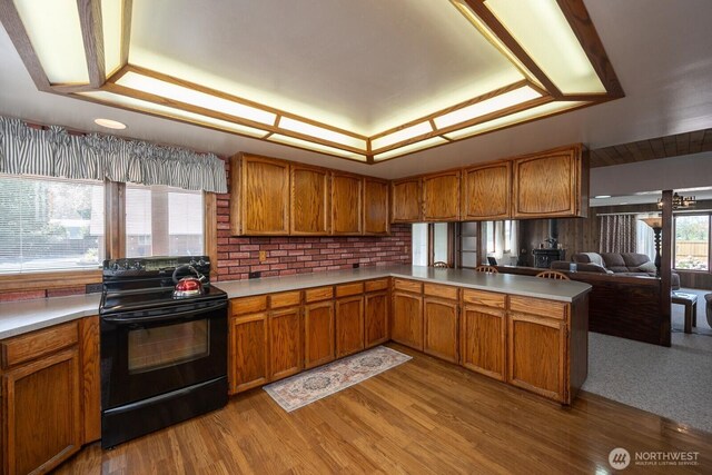 710 S Mckinney Rd, Othello, WA 99344 - kitchen with black / electric stove, brown cabinetry, light countertops, and light wood-style floors