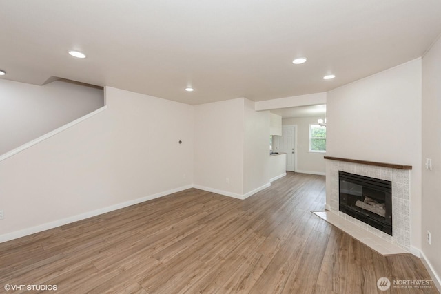 10923 63rd St E, Puyallup, WA 98372 - unfurnished living room featuring recessed lighting, light wood-style floors, baseboards, and a tile fireplace