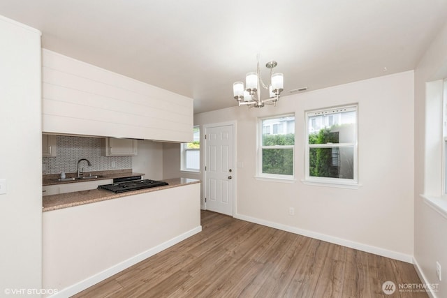 10923 63rd St E, Puyallup, WA 98372 - kitchen featuring a sink, light wood-style flooring, a chandelier, and baseboards