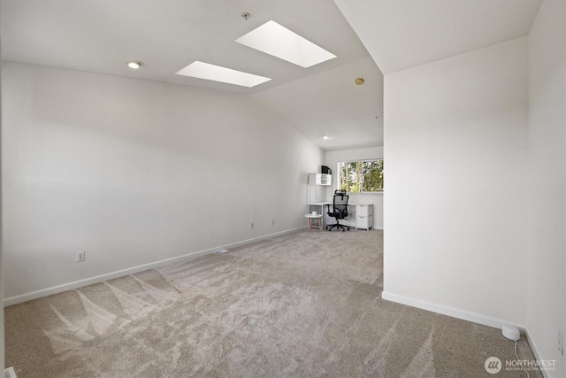 2311 Milton Way Unit E, Milton, WA 98354 - unfurnished living room with a skylight, carpet floors, baseboards, vaulted ceiling, and a desk
