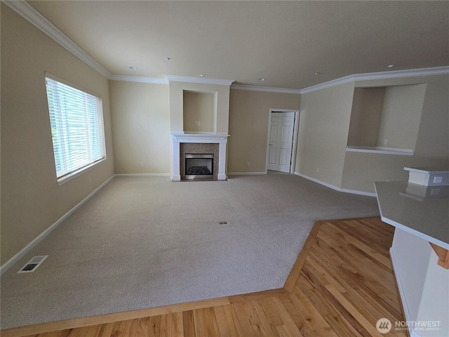 1301 67th St SE Unit 16A, Auburn, WA 98092 - unfurnished living room with baseboards, a fireplace with flush hearth, ornamental molding, wood finished floors, and carpet flooring