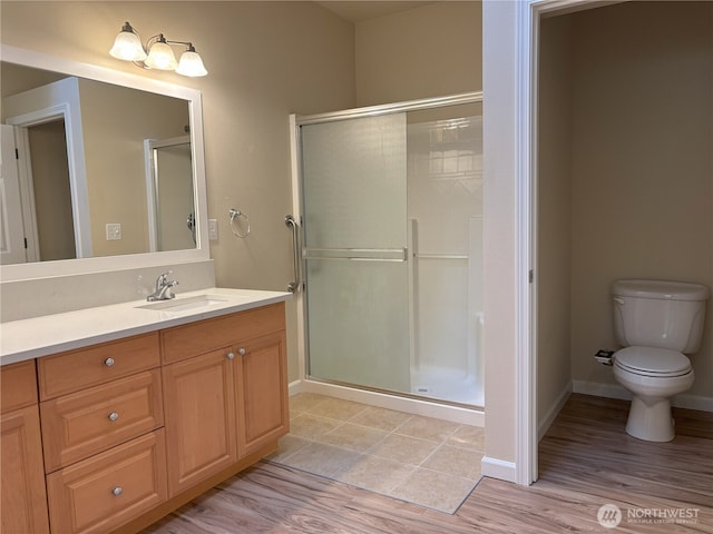 1301 67th St SE Unit 16A, Auburn, WA 98092 - bathroom with vanity, a shower stall, toilet, wood finished floors, and baseboards