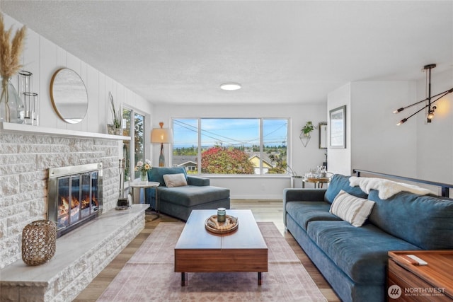 4210 N Vassault St, Tacoma, WA 98407 - living area featuring wood finished floors, a fireplace, baseboards, and a textured ceiling