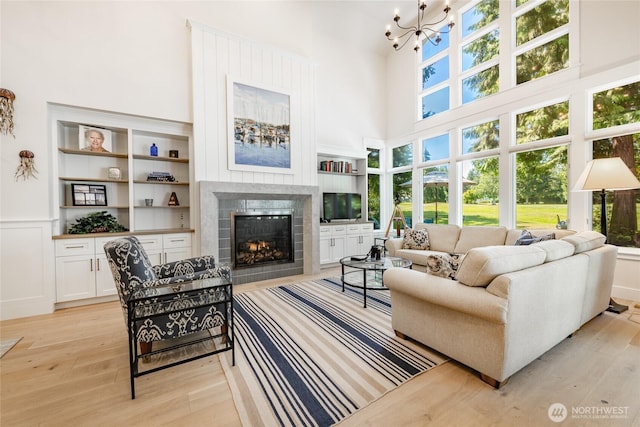 5552 Canvasback Rd, Blaine, WA 98230 - living area featuring a high ceiling, light wood finished floors, a fireplace, a chandelier, and built in features