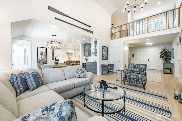 5552 Canvasback Rd, Blaine, WA 98230 - living area featuring a chandelier, light wood-style floors, beverage cooler, and a towering ceiling