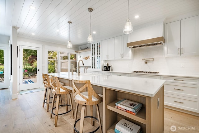 5552 Canvasback Rd, Blaine, WA 98230 - kitchen with open shelves, an island with sink, light wood-style flooring, tasteful backsplash, and wooden ceiling