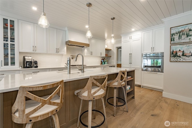 5552 Canvasback Rd, Blaine, WA 98230 - kitchen featuring oven, wood ceiling, custom range hood, a sink, and light wood-style floors