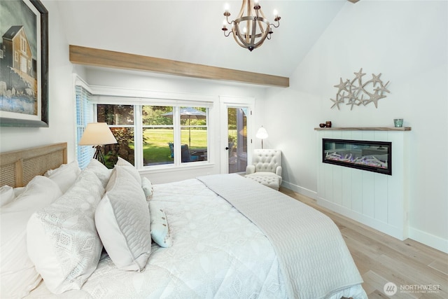 5552 Canvasback Rd, Blaine, WA 98230 - bedroom with wood finished floors, a chandelier, baseboards, a glass covered fireplace, and vaulted ceiling