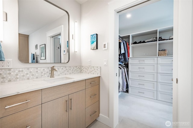 5552 Canvasback Rd, Blaine, WA 98230 - bathroom featuring vanity, a spacious closet, baseboards, and backsplash