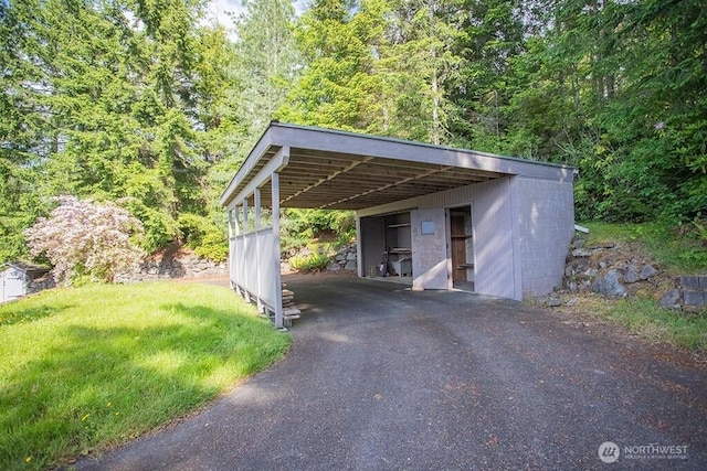 12289 Seabeck Hwy NW, Seabeck, WA 98380 - view of parking featuring a carport, asphalt driveway, and a wooded view