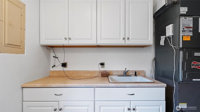 810 E Spring, Dayton, WA 99328 - kitchen with a sink, electric panel, white cabinets, and heating unit