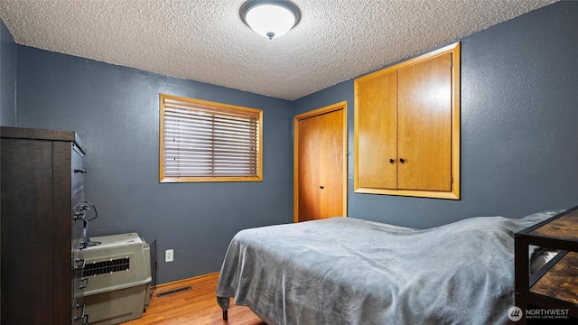 810 E Spring, Dayton, WA 99328 - bedroom with a textured ceiling, light wood-type flooring, a closet, and a textured wall