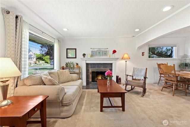 4325 E B St, Tacoma, WA 98404 - living area with healthy amount of natural light, a tiled fireplace, a textured ceiling, light colored carpet, and recessed lighting