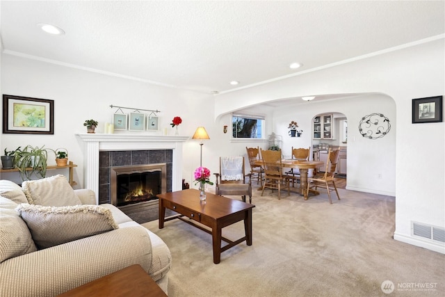 4325 E B St, Tacoma, WA 98404 - living area featuring arched walkways, a tile fireplace, recessed lighting, light colored carpet, and baseboards
