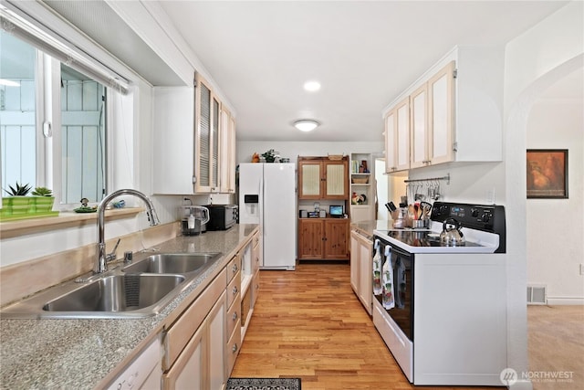 4325 E B St, Tacoma, WA 98404 - kitchen with white appliances, a sink, arched walkways, light countertops, and light wood finished floors