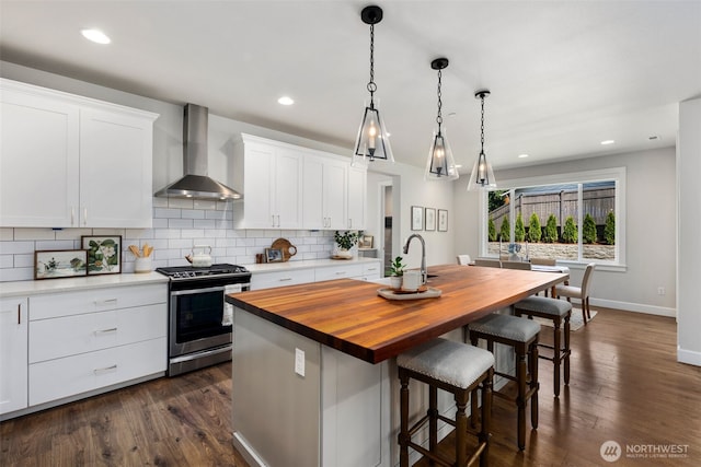 8009 197th Ave E, Bonney Lake, WA 98391 - kitchen featuring wall chimney range hood, stainless steel gas range oven, butcher block countertops, a center island with sink, and backsplash
