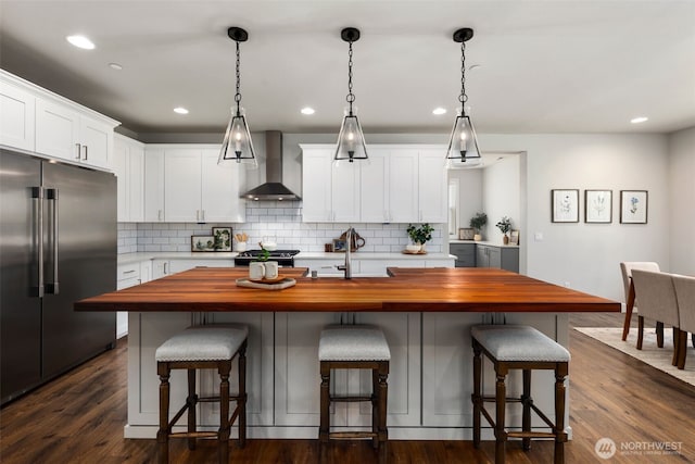 8009 197th Ave E, Bonney Lake, WA 98391 - kitchen with wall chimney range hood, stainless steel appliances, butcher block counters, backsplash, and recessed lighting
