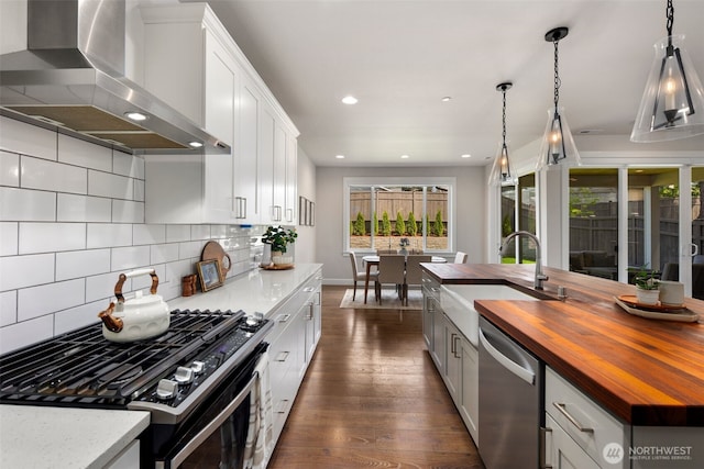 8009 197th Ave E, Bonney Lake, WA 98391 - kitchen with wooden counters, wall chimney exhaust hood, dishwasher, black gas stove, and dark wood-type flooring