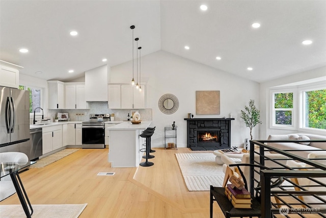 236 S 316th Pl, Federal Way, WA 98003 - kitchen with stainless steel appliances, plenty of natural light, a breakfast bar area, light countertops, and high vaulted ceiling