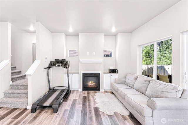 2912 Sandwood Ln, Blaine, WA 98230 - living area with wood finished floors, a glass covered fireplace, stairway, and recessed lighting