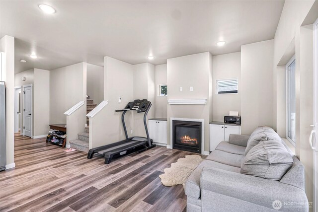 2912 Sandwood Ln, Blaine, WA 98230 - living area with wood finished floors, stairs, a glass covered fireplace, recessed lighting, and baseboards