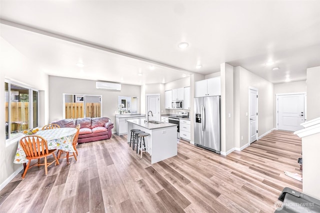 2912 Sandwood Ln, Blaine, WA 98230 - kitchen featuring appliances with stainless steel finishes, a wall mounted air conditioner, a sink, a kitchen breakfast bar, and open floor plan